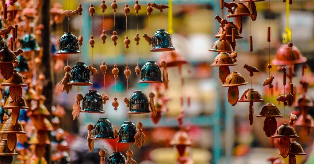 Vibrant hanging bells and ornaments in a pottery market stall, showcasing cultural artistry.