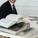 A lawyer sitting at a desk with legal books, documents, and a newspaper, embodying professionalism.