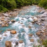A tranquil river winding through dense forest and rocky terrain in Taiwan, perfect for nature enthusiasts.