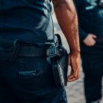 Close-up of a police officer's firearm securely holstered at the waist, conveying professionalism and readiness.