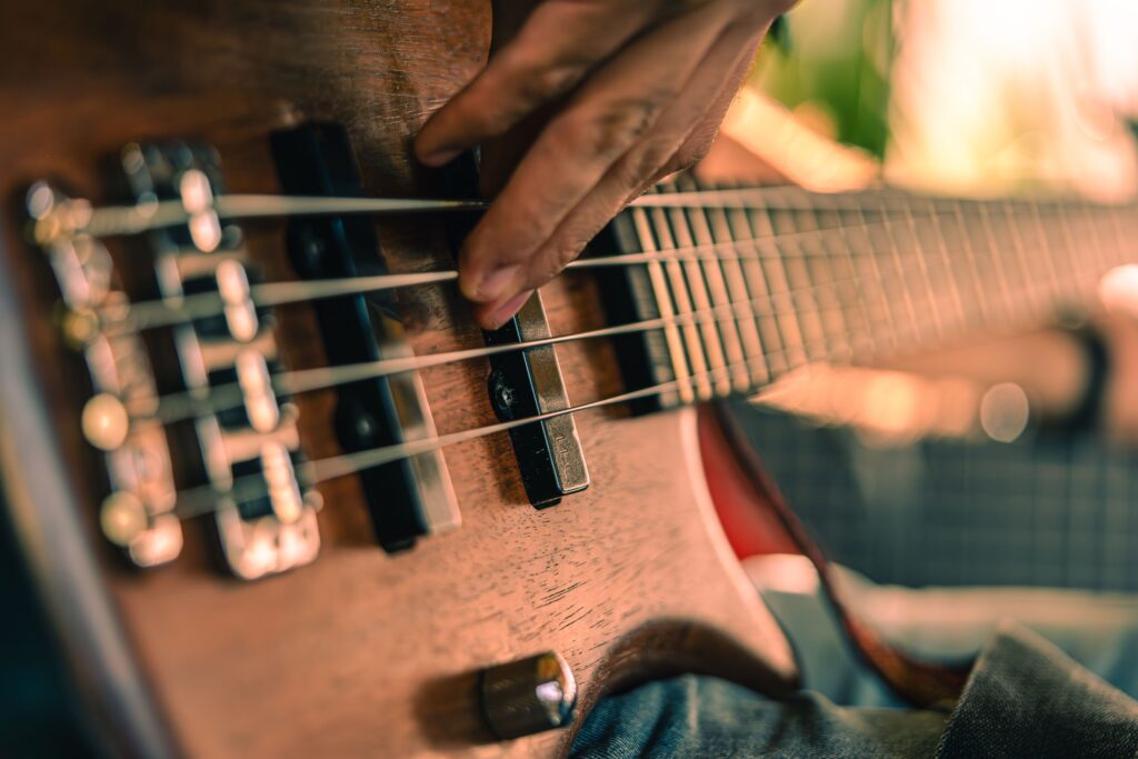 A detailed shot of a musician playing a bass guitar, showcasing musical performance intensity.