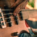 A detailed shot of a musician playing a bass guitar, showcasing musical performance intensity.