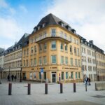 A scenic view of a bustling town square in Luxembourg city, showcasing classic European architecture.